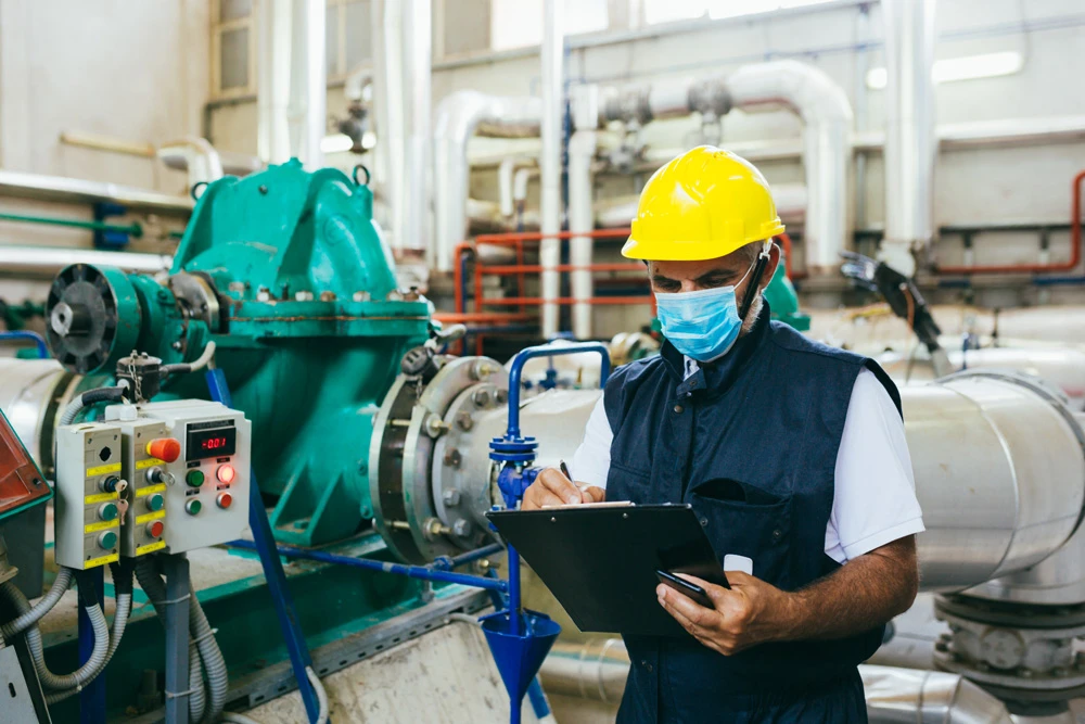 worker in protective equipment working indoor in industry plant