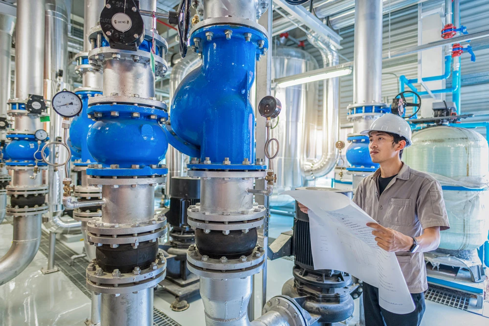 Young man mechanical engineer holding drawing to checking and inspection of HVAC heating ventilation